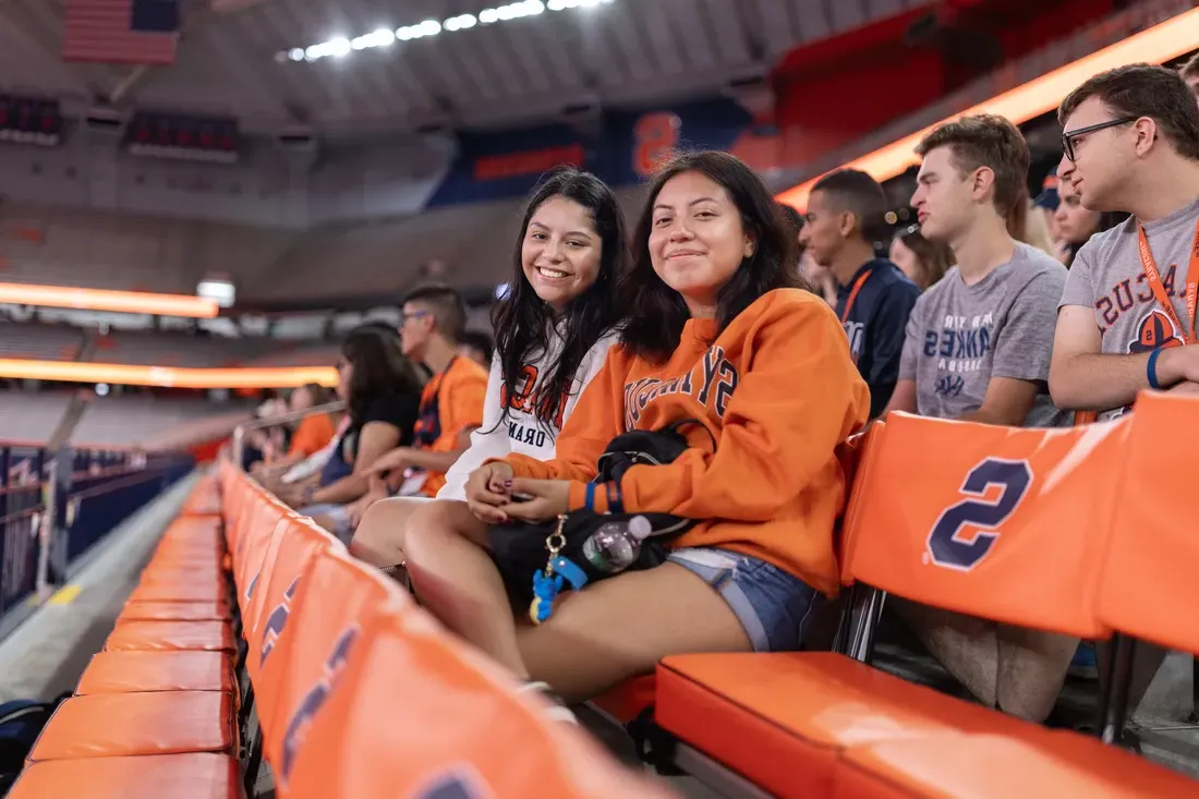 People sitting in a stadium and smiling.